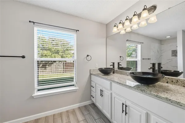 a bathroom with a granite countertop sink and a large mirror