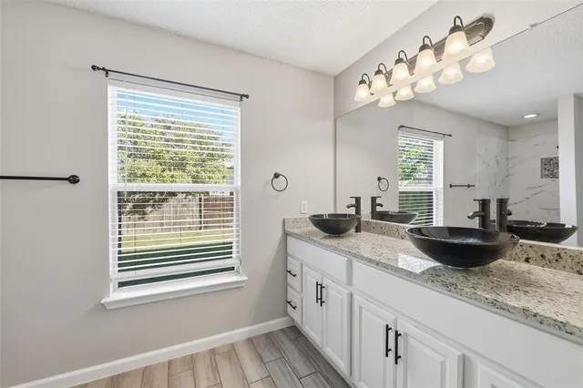 a bathroom with a granite countertop sink and a large mirror