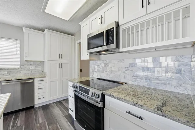 a kitchen with stainless steel appliances granite countertop a stove and a microwave