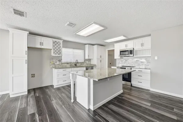 a kitchen with white cabinets stainless steel appliances and sink