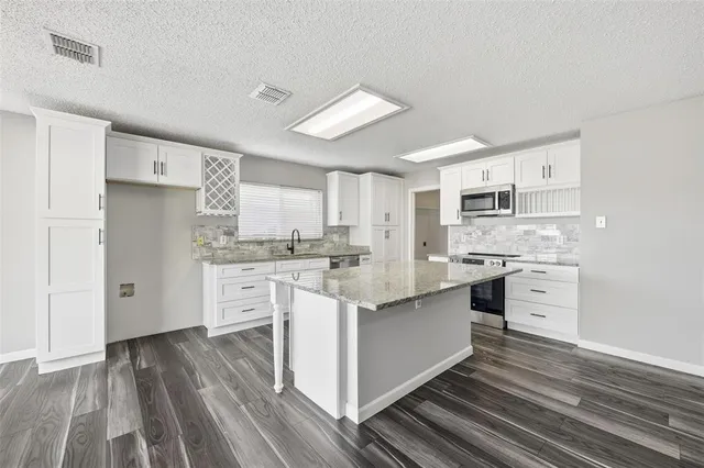 a kitchen with white cabinets stainless steel appliances and sink