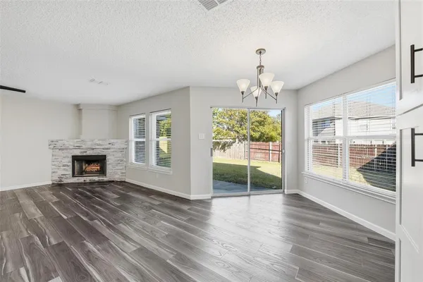 a view of an empty room with a fireplace and a window