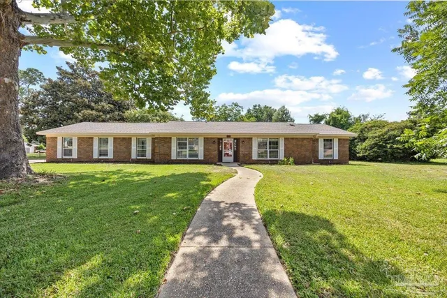 a front view of house with a garden