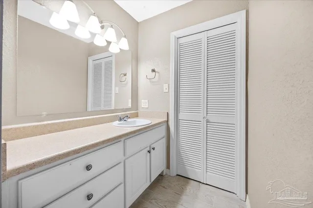 a bathroom with a sink a vanity and a large mirror