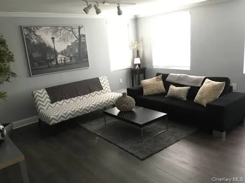 a living room with furniture and a painting on the wall