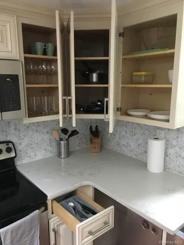 a kitchen with a sink and a stove with wooden floor