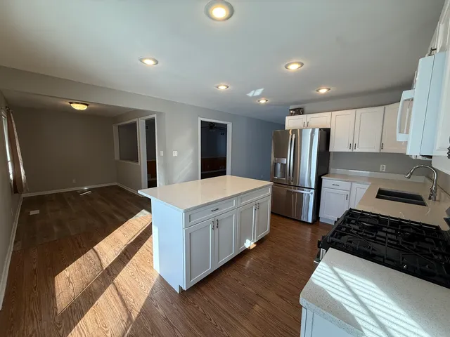a kitchen with stainless steel appliances granite countertop a refrigerator and a stove