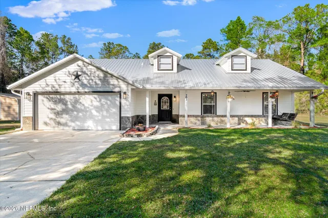 a front view of a house with a garden and plants