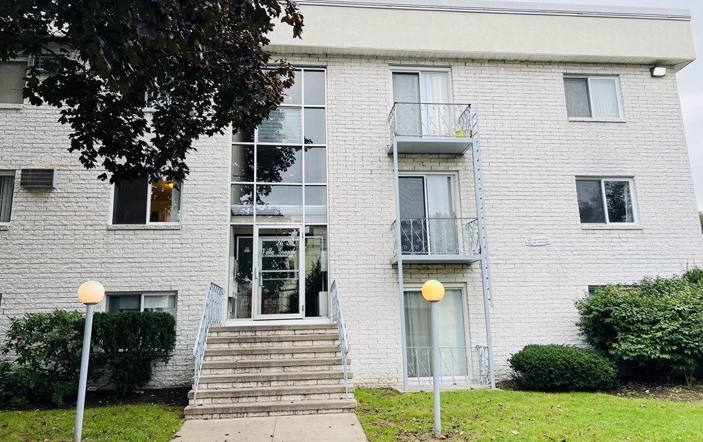 24-26 Inman Street, Unit 28 Lawrence, MA 01843 - Photo 1 of 13 a front view of a house with a garden