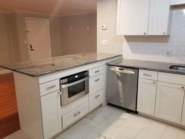 a kitchen with white cabinets and white appliances