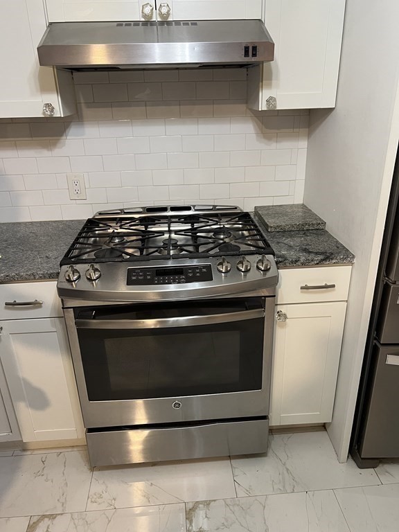 24-26 Inman Street, Unit 28 Lawrence, MA 01843 - Photo 9 of 13 a stove top oven sitting inside of a kitchen