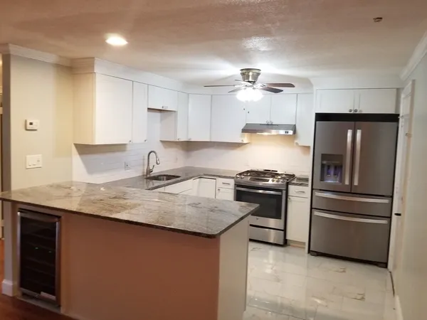 a kitchen with stainless steel appliances granite countertop a sink stove and refrigerator
