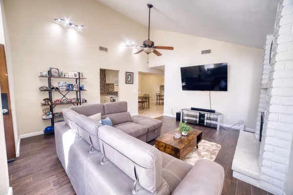 a living room with furniture a flat screen tv and a view of kitchen