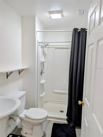 a bathroom with a toilet and a shower