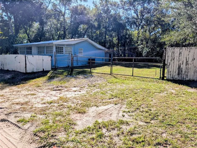 a view of backyard with swimming pool and seating space