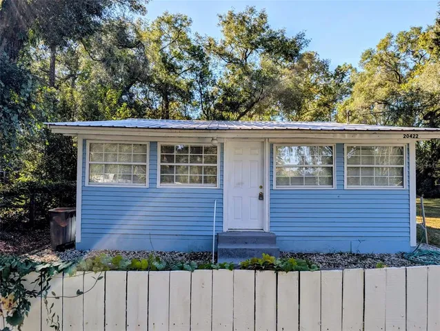 a view of a house with a wooden fence