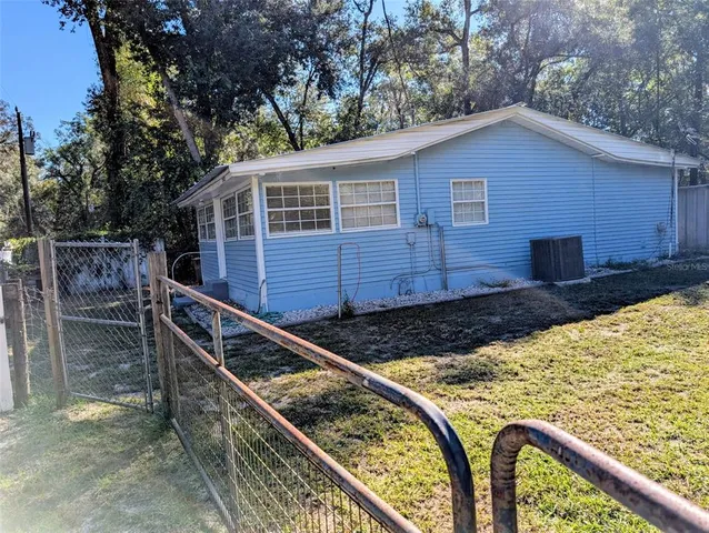 a view of a house with backyard and sitting area