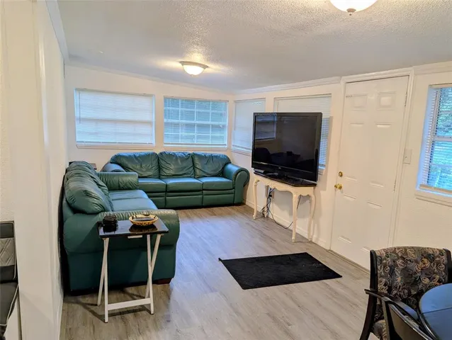 a living room with furniture a flat screen tv and a window