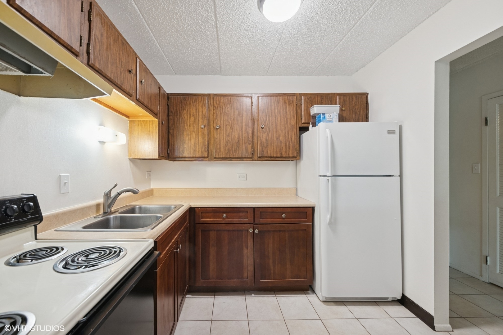 9701 North Dee Road, Unit 2I Niles, IL 60714 - Photo 5 of 24 a kitchen with a sink a refrigerator and cabinets