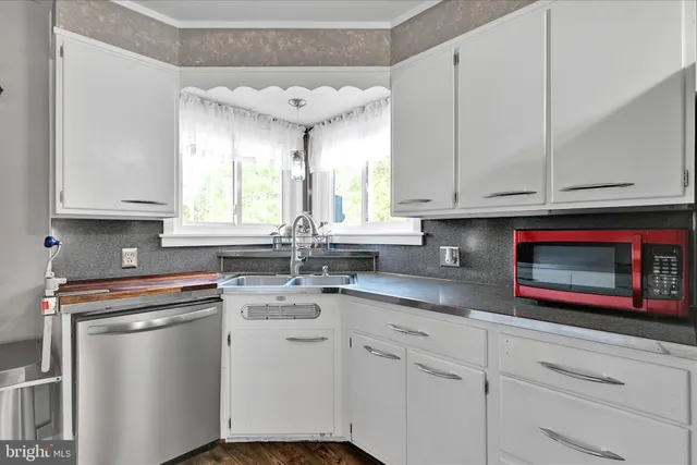 a kitchen with granite countertop white cabinets and white appliances