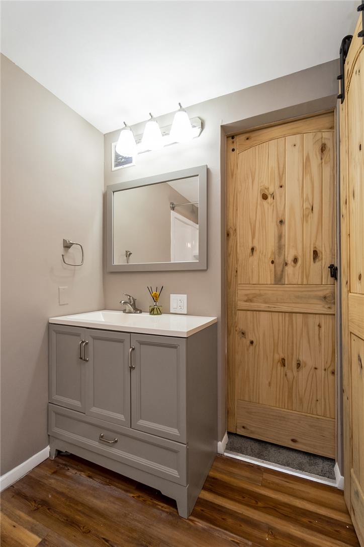 121 Short Ridge Road Albrightsville, PA 18210 - Photo 18 of 35 A stylish vanity and distinctive sliding wooden doors elevate this functional bathroom space.