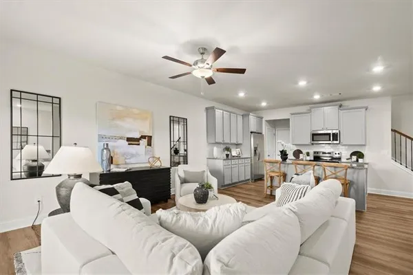 a living room with furniture kitchen view and a chandelier