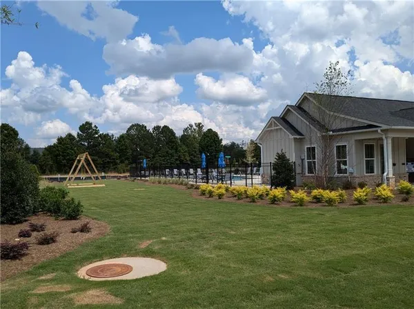 a swimming pool view with a seating space and fir pit