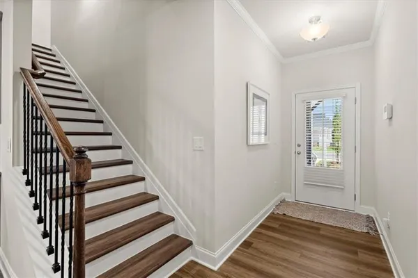 a view of a hallway with wooden floor and entryway