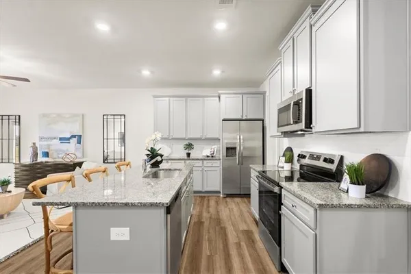 a kitchen with sink a microwave and cabinets