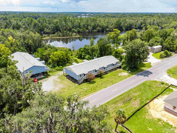 an aerial view of a house with a yard and lake view
