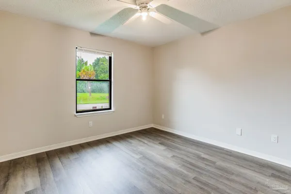 an empty room with a window and a ceiling fan
