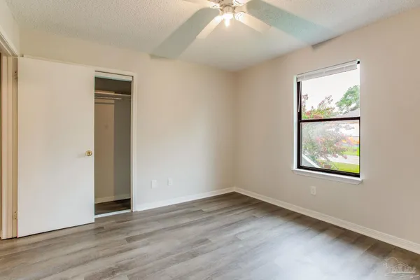 an empty room with wooden floor and windows