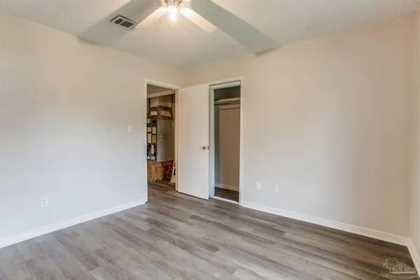 an empty room with wooden floor and closet