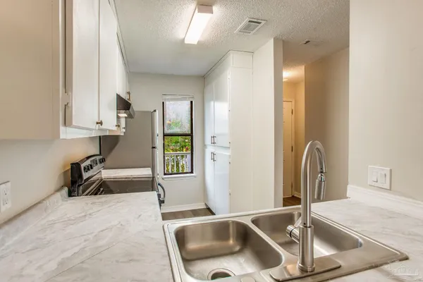 a kitchen with a sink a counter top space and cabinets