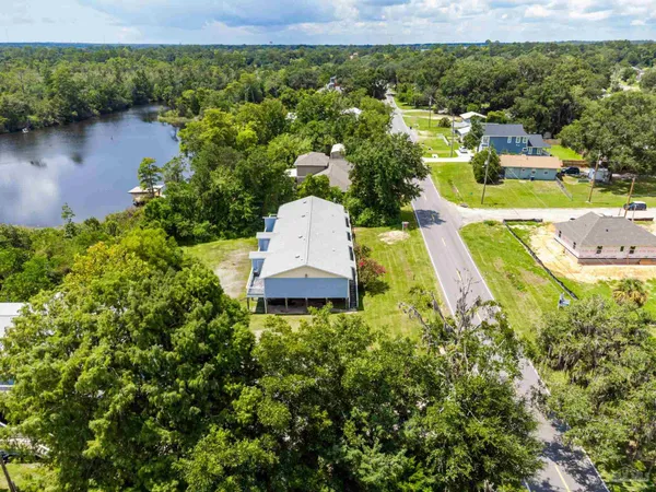 an aerial view of a house with garden space and lake view