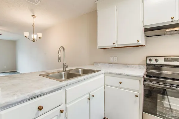 a kitchen with granite countertop a sink and cabinets