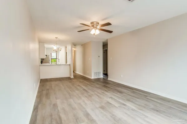 a view of an empty room and window with a fan