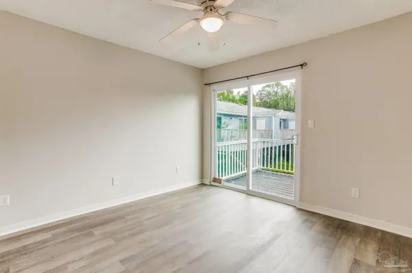 an empty room with wooden floor and balcony