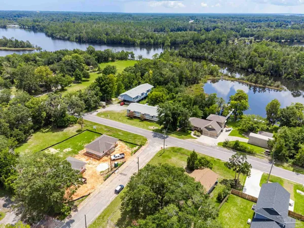 an aerial view of a house with a garden and lake view