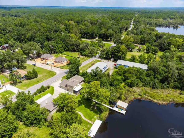an aerial view of residential houses with outdoor space and trees all around
