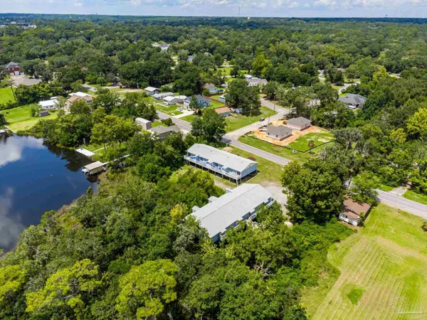 an aerial view of residential houses with outdoor space and trees