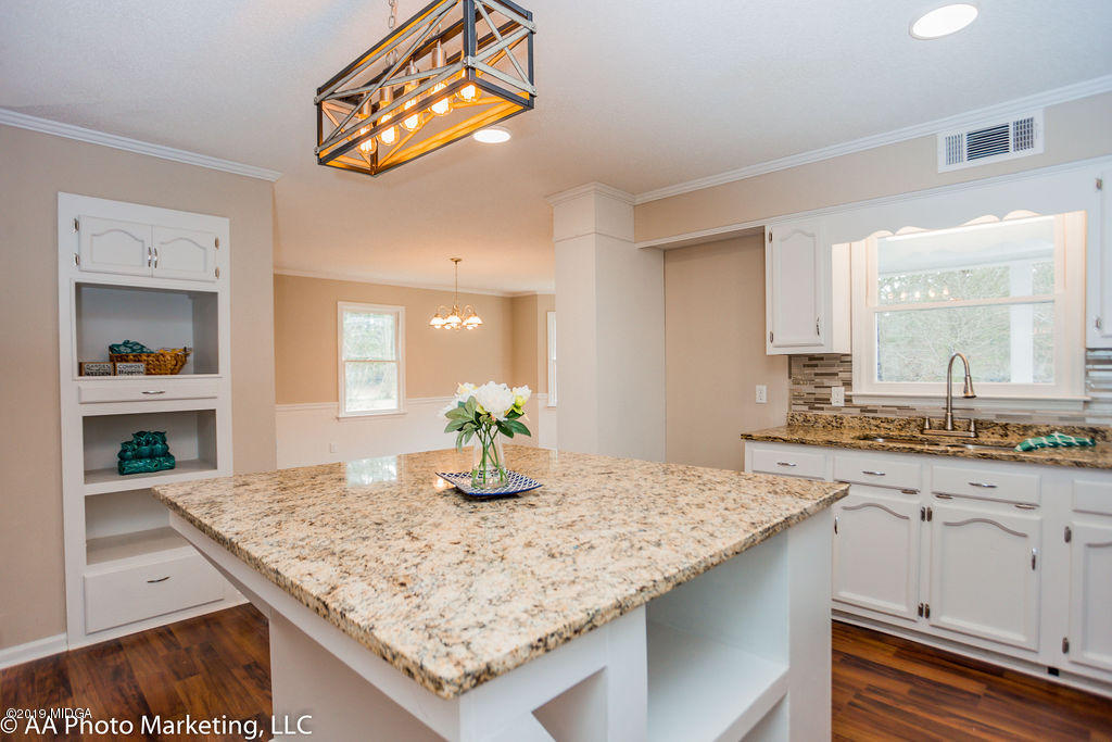922 Woolfolk Road Fort Valley, GA 31030 - Photo 11 of 38 a kitchen with granite countertop sink and cabinets