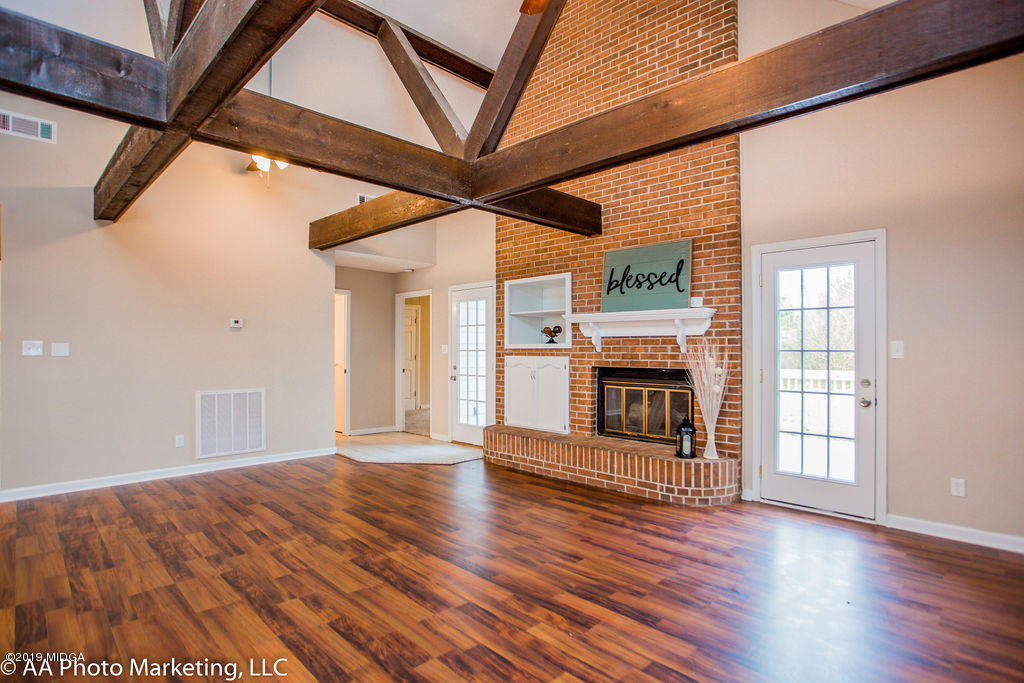 922 Woolfolk Road Fort Valley, GA 31030 - Photo 16 of 38 an empty room with wooden floor fireplace and windows