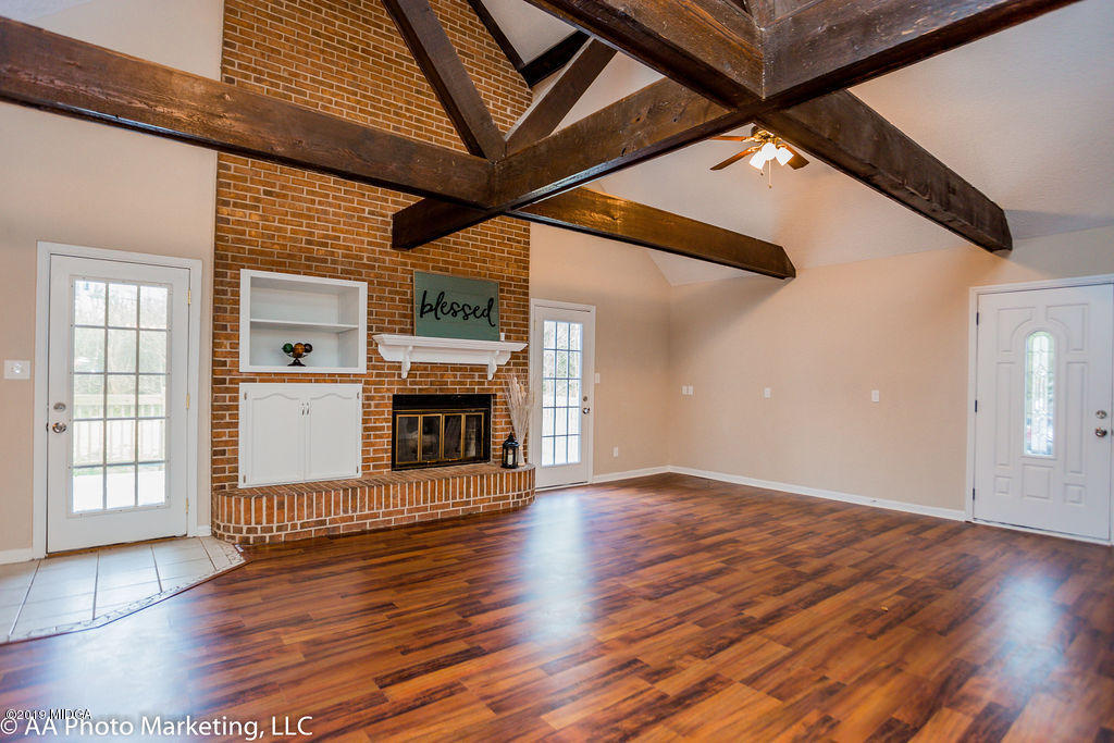 922 Woolfolk Road Fort Valley, GA 31030 - Photo 17 of 38 an empty room with wooden floor fireplace and windows