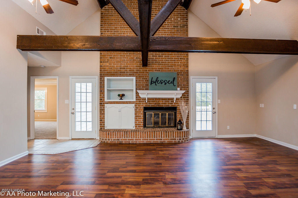 922 Woolfolk Road Fort Valley, GA 31030 - Photo 18 of 38 an empty room with wooden floor and fireplace