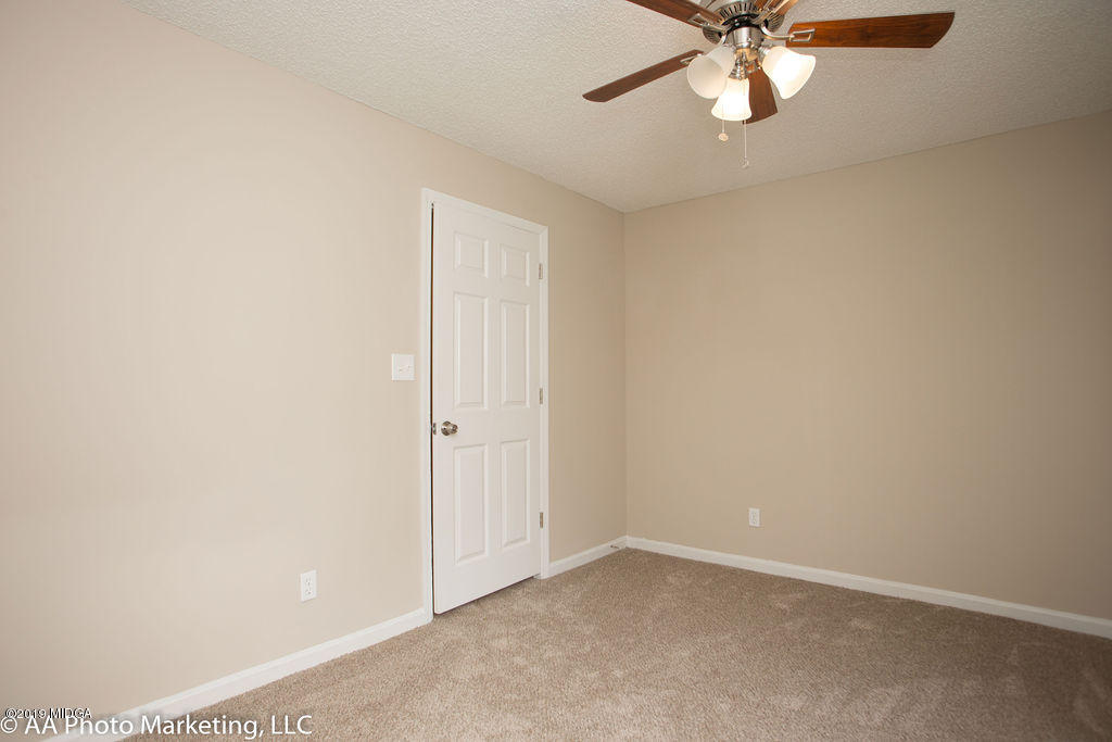 922 Woolfolk Road Fort Valley, GA 31030 - Photo 25 of 38 an empty room with a window and a chandelier fan