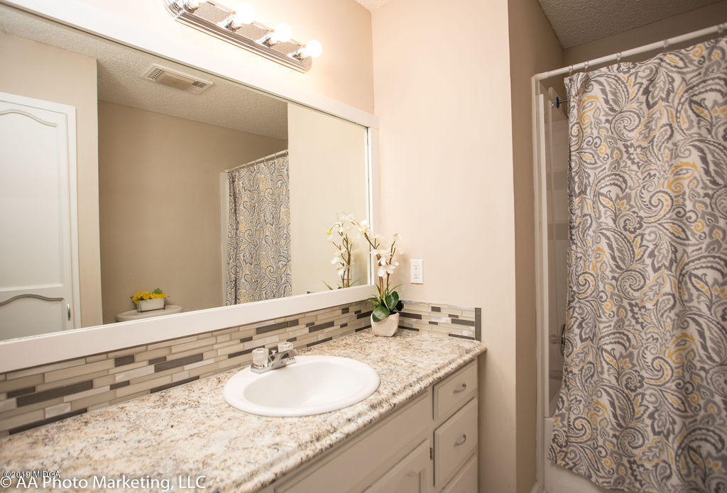 922 Woolfolk Road Fort Valley, GA 31030 - Photo 30 of 38 a bathroom with a granite countertop sink and a mirror