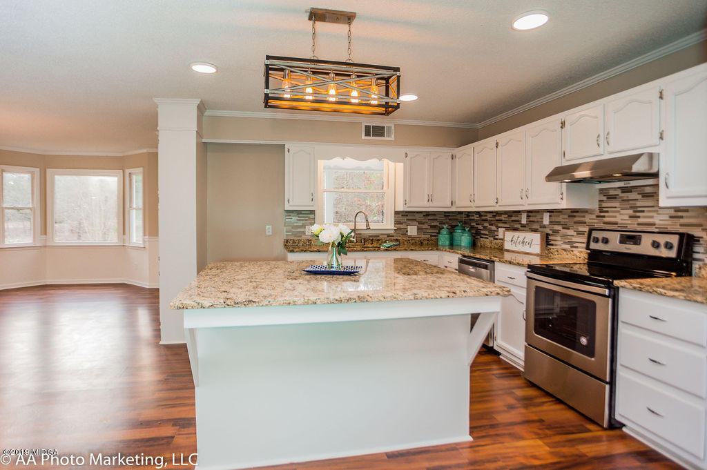 922 Woolfolk Road Fort Valley, GA 31030 - Photo 5 of 38 a kitchen with kitchen island granite countertop a sink cabinets and stainless steel appliances