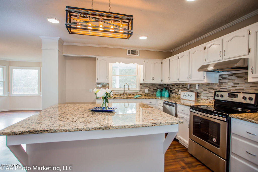 922 Woolfolk Road Fort Valley, GA 31030 - Photo 6 of 38 a kitchen with granite countertop a sink a stove and cabinets