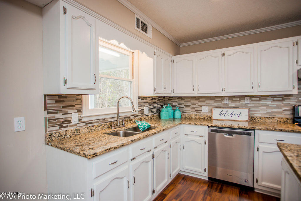 922 Woolfolk Road Fort Valley, GA 31030 - Photo 7 of 38 a kitchen with granite countertop a sink white cabinets and white appliances